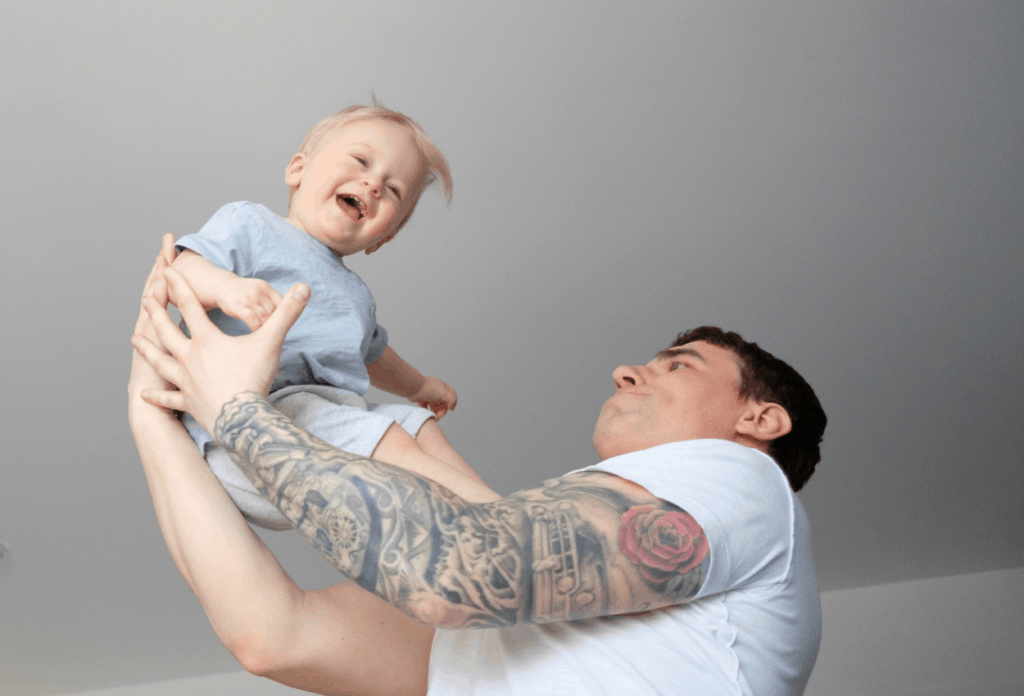 dad holding laughing child